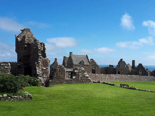 Remains of a historic stone castle on a sunny day with green lawns